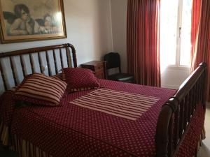 罗萨里奥港Mi casa的一间卧室配有一张红色棉被的床