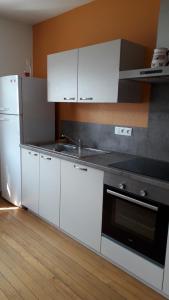 马泽内姆13 Rue de Sand的厨房配有白色橱柜、炉灶和冰箱。