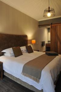 布隆方丹Kestell Stables的卧室配有一张白色大床和棕色床头板