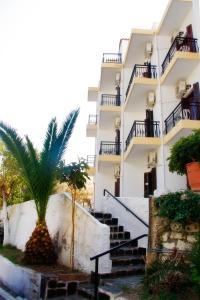阿基奥斯基利考斯瑞纳酒店的一座有楼梯的建筑,前面有棕榈树