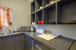 伯诺尼The Minimalist Studio B的厨房配有带水槽和柜台的四柱床