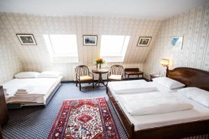 维也纳亚特兰大酒店的一间卧室配有两张床和一张桌子及椅子