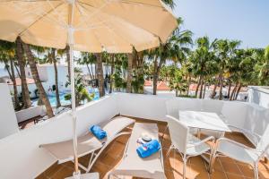 科斯塔卡玛Bahia Calma Beach的阳台配有桌椅和遮阳伞。