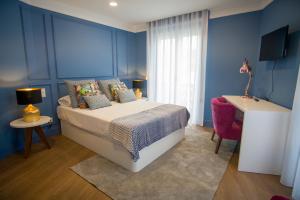 普拉亚达维多利亚ZIGZAG HOSTEL的蓝色的卧室设有床和窗户