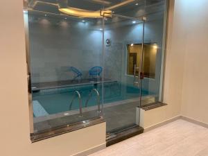 艾卜哈Violette Chalet的浴室内设有一个游泳池及玻璃淋浴间