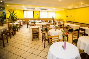 维也纳格比乐嘉瑟酒店的餐厅设有白色的桌椅和黄色的墙壁