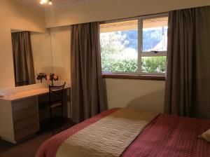 皮克顿AAA马林汽车旅馆的一间卧室配有一张床、一张书桌和一个窗户。