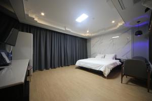 釜山Bestie Hotel的配有一张床和一张书桌的酒店客房