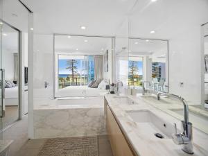 黄金海岸尼瓦纳海滨公寓的一间带大浴缸和大镜子的浴室