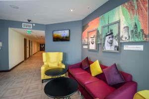 迪拜迪拜矽谷绿洲普瑞米尔酒店的客厅配有红色沙发和黄色椅子
