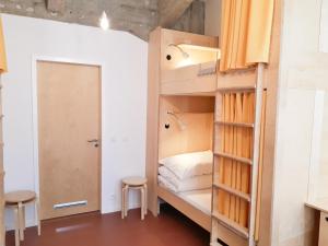 拉贝河畔乌斯季CMYK Ústí nad Labem的一间设有一张双层床和两张凳子的房间