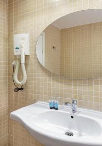 内坦亚米兹普亚姆精品酒店的浴室水槽、镜子和电话