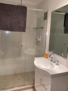 金斯科特因娜纳特度假屋的浴室配有白色水槽和淋浴。