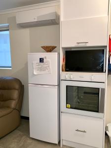金斯科特因娜纳特度假屋的微波炉旁的白色冰箱以及微波炉