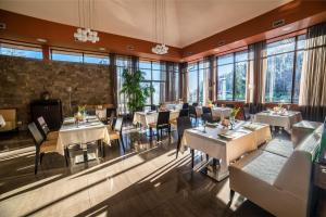 尼日尔索洛维诺Hotel Irys by Derenivska Kupil的餐厅设有桌椅和大窗户。