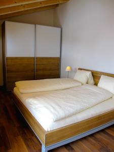 贝特默阿尔卑Bergquelle Dachwohnung的一间卧室配有一张大床和木制床头板