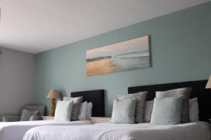 布什米尔斯考斯威酒店的两张位于酒店客房的床,墙上挂着一幅画