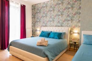 阿西西Assisi Panoramic Rooms的一间卧室配有一张带蓝色枕头的大床