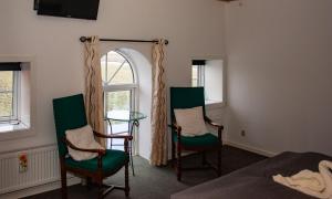 伯卢姆Ballum Slusekro的一间卧室配有两把椅子、一面镜子和一张桌子