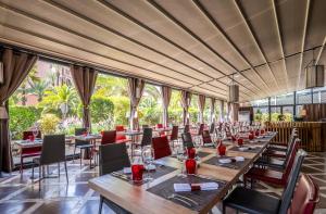 马拉喀什海微尼格spa酒店 的餐厅设有桌椅和大窗户。