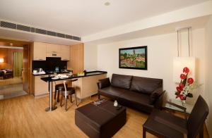 新德里Svelte Hotel and Personal Suites的客厅以及带沙发和桌子的厨房。