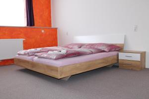 Haslach an der MühlGasthof-Cafe-Risano的一间卧室配有一张木架床和一张桌子