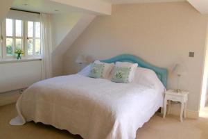 亨格福德Thatched Cottage的一间卧室配有一张白色的床和蓝色床头板