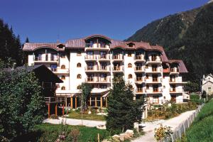 夏蒙尼-勃朗峰阿让拉格朗日水晶度假酒店的一座白色的大建筑,有红色的屋顶