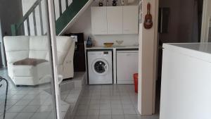 卡布勒通Villa patio à 200 m de la plage à Capbreton的洗衣房设有洗衣机和烘干机以及楼梯。