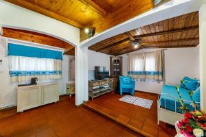 圣特雷莎加卢拉Saltara的客厅设有木制天花板和蓝色椅子。