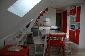Faverollesle four à pain的厨房配有红色和白色的橱柜和红色的椅子