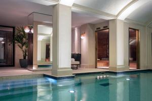 巴黎Les Jardins du Faubourg Hotel & Spa by Shiseido的一座有柱子的房子和一室的游泳池