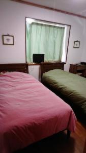 宫古岛Miyakojima - house / Vacation STAY 270的一间卧室设有两张床,窗户配有笔记本电脑