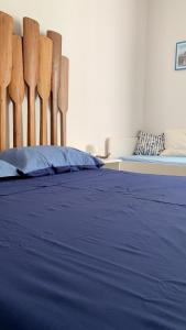 莫尔费塔SUD 47的一间卧室配有一张带蓝色床单和木椅的床。