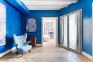 米兰Galleria Vik Milano的一间拥有蓝色墙壁和蓝色椅子的房间