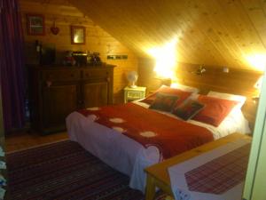 莱托利Chalet Gérardmer situé a LE THOLY的木制客房内的一间卧室,配有一张床