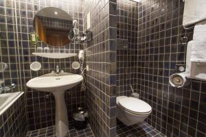 因斯布鲁克加尼罗密霍夫酒店的蓝色瓷砖浴室设有卫生间和水槽