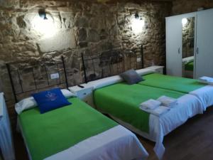帕拉斯德丽Hosteria Calixtino的石墙客房的两张床