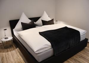 锡默拉特Zum Anker的一张配有黑白床单和枕头的床