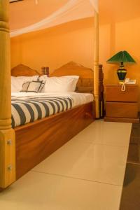 MbaleKayegi Hotel Mbale的一间卧室配有一张木架床
