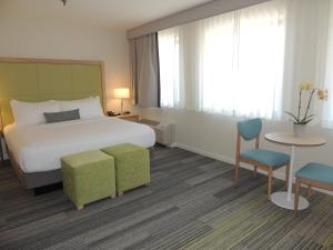 波士顿朗伍德疗养酒店的酒店客房带一张床、一张桌子和椅子