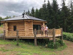 赫里福德Coed y Marchog Woodland Retreat的两名妇女站在小木屋的门廊上