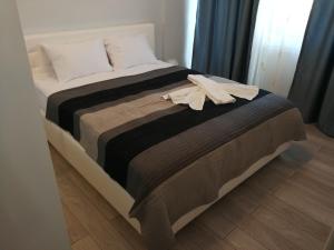 马马亚Inima Mamaia LuxyMar 2 Apartment的一张带棕色毯子的床和一件浴袍