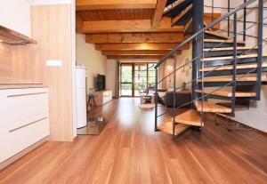 日茄基Apartmán U Sikorek的客厅铺有木地板,设有螺旋楼梯。