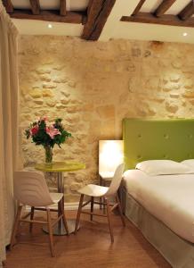 巴黎金厄尔斯酒店的一间卧室配有一张床和一张桌子及椅子