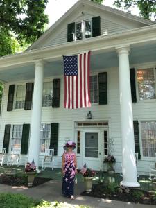 索格蒂斯伦威克利夫顿住宿加早餐旅馆的站在有美国国旗的房子前的妇女
