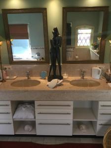 Schijndel斯海德尔豪华住宿加早餐旅馆的浴室设有两个盥洗盆,柜台上装饰有女人的雕像