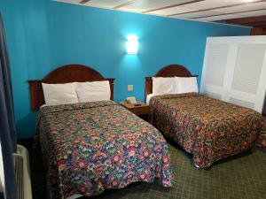 罗斯威尔梅奥汽车旅馆的酒店客房设有两张床和蓝色的墙壁。