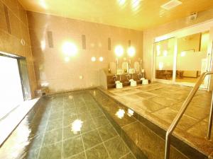 龟山鲁特因戴尼卡亚玛英特酒店的大型客房,位于一座大楼内,设有游泳池