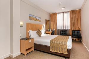 珀斯珀斯大使馆品质酒店的配有一张床和一张书桌的酒店客房